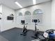 Well-equipped gym with stationary bikes, rowing machine, and natural light from arched windows at 805 Suffolk Pl, Davenport, FL 33896