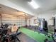 Spacious home gym featuring weightlifting equipment, a treadmill, green carpet, and durable black floor tiles at 805 Suffolk Pl, Davenport, FL 33896