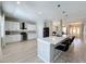 Open concept kitchen with white cabinets, stainless steel appliances, and a spacious island with seating at 805 Suffolk Pl, Davenport, FL 33896
