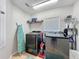 Functional laundry room featuring modern washer, dryer, ironing board, and storage shelves at 805 Suffolk Pl, Davenport, FL 33896