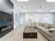 Comfortable lounge area featuring a large sectional sofa, coffee table, and a modern fireplace at 805 Suffolk Pl, Davenport, FL 33896