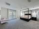 Spacious main bedroom features a four-poster bed, balcony access, and a cozy ambiance at 805 Suffolk Pl, Davenport, FL 33896