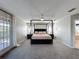 Serene main bedroom with four-poster bed, private balcony, and elegant decor at 805 Suffolk Pl, Davenport, FL 33896