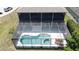 Aerial view of the screened-in pool area, featuring a geometric pool design and patio furniture at 805 Suffolk Pl, Davenport, FL 33896
