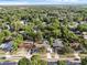 Aerial view of the neighborhood showing a home with a backyard pool, surrounded by dense trees at 807 E Airport Blvd, Sanford, FL 32773