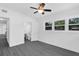 Bright bedroom with wood-look flooring, ceiling fan, ensuite bathroom, and natural light from multiple windows at 807 E Airport Blvd, Sanford, FL 32773