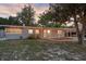 Charming single story home with welcoming front porch and a well-maintained yard under a beautiful sunset at 807 E Airport Blvd, Sanford, FL 32773