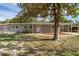 Single-story home features a cozy porch, warm lighting, and an inviting front yard shaded by mature trees at 807 E Airport Blvd, Sanford, FL 32773