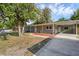 Single-story home with front yard, carport, decorative lighting, and tidy landscaping, perfect for curb appeal at 807 E Airport Blvd, Sanford, FL 32773