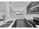 Open kitchen with gray cabinets, stainless steel appliances, and an adjacent dining area at 807 E Airport Blvd, Sanford, FL 32773