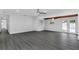 Bright living area with gray floors, ceiling fan, and double glass doors that lead to a backyard pool at 807 E Airport Blvd, Sanford, FL 32773