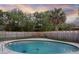 This backyard features a private pool with string lights on the wooden fence, and palm trees at 807 E Airport Blvd, Sanford, FL 32773