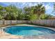 This backyard features a sparkling pool, surrounded by green trees at 807 E Airport Blvd, Sanford, FL 32773