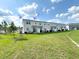 Townhome backyard featuring lush green grass and direct access to the home's sliding glass doors at 921 Spring Palms Loop, Orlando, FL 32828