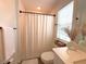 Bright bathroom featuring a shower with curtain, window, and decorative vase at 921 Spring Palms Loop, Orlando, FL 32828