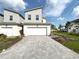 Modern two-story home with a two car garage, neutral paint, paved driveway, and minimal landscaping at 921 Spring Palms Loop, Orlando, FL 32828