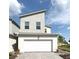 Modern two-story home featuring a two-car garage and contemporary architectural design under a bright blue sky at 921 Spring Palms Loop, Orlando, FL 32828
