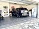 Attached garage features epoxy flooring, painted cinderblock walls, and a modern car at 921 Spring Palms Loop, Orlando, FL 32828