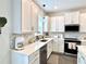 Modern kitchen featuring white cabinets, stainless steel appliances, and marble backsplash at 921 Spring Palms Loop, Orlando, FL 32828