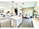 Open-concept kitchen features a white island, granite countertops, and pendant lighting adjacent to a dining area at 921 Spring Palms Loop, Orlando, FL 32828