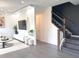 Open-concept living room with stylish decor, modern staircase, and abundant natural light at 921 Spring Palms Loop, Orlando, FL 32828