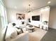Bright living room featuring a white sofa, entertainment center, and a modern light fixture over a round coffee table at 921 Spring Palms Loop, Orlando, FL 32828