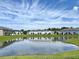Scenic pond surrounded by well-manicured lawns and townhome-style houses in the background at 921 Spring Palms Loop, Orlando, FL 32828