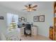 Bright bedroom featuring a ceiling fan, desk with dual monitors, and a crib next to the window at 1139 Seedorf Dr, Winter Haven, FL 33881