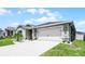 Home exterior featuring a two-car garage and a well-manicured lawn with decorative rock at 1139 Seedorf Dr, Winter Haven, FL 33881