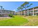 Exterior view of condo buildings with well-maintained lawn and mature trees at 115 Oyster Bay Byu # 115, Altamonte Springs, FL 32701