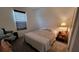 Bedroom featuring carpet, a bed, and a dark shade, with a small side table adorned with personal belongings at 12372 Stone Bark Trl, Orlando, FL 32824