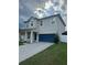 Two-story home featuring a two-car garage, a charming covered front porch, and well-maintained landscaping at 12372 Stone Bark Trl, Orlando, FL 32824