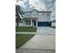 Two-story home featuring a well-maintained lawn, a two-car garage, and a charming covered front porch at 12372 Stone Bark Trl, Orlando, FL 32824