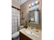 Nautical-themed bathroom features a decorative mirror, neutral walls, and a stylish shower curtain at 13 W Marbrisa Way, Kissimmee, FL 34743