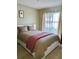 Comfortable bedroom with neutral-toned bedding, side window with white sheer curtains and blackout panels at 13 W Marbrisa Way, Kissimmee, FL 34743