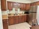 Galley-style kitchen featuring warm wood cabinetry, stainless-steel appliances and a neutral countertop at 13 W Marbrisa Way, Kissimmee, FL 34743