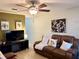 Cozy living room with a ceiling fan, wood-look floors, leather seating and warm, neutral decor at 13 W Marbrisa Way, Kissimmee, FL 34743