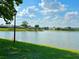Scenic view of the community pond framed by lush green grass under a bright blue sky at 13 W Marbrisa Way, Kissimmee, FL 34743