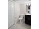 A bathroom featuring a toilet, dark vanity with sink, tile flooring, and a closet at 1312 Royal St George Blvd, Davenport, FL 33896
