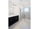Bright bathroom with a glass-door shower and dark vanity with a single sink at 1312 Royal St George Blvd, Davenport, FL 33896