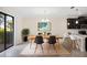 A bright dining room with modern table setting, rug, and black kitchen cabinets at 1312 Royal St George Blvd, Davenport, FL 33896