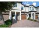 Charming townhome showing landscaped front, private garage, and brick driveway at 1312 Royal St George Blvd, Davenport, FL 33896