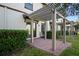 Back patio with brick, leading to door, with trimmed bushes at 1312 Royal St George Blvd, Davenport, FL 33896