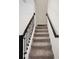 Carpeted stairway with dark wooden railings and white walls providing a modern and safe transition at 1312 Royal St George Blvd, Davenport, FL 33896