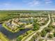 An aerial shot highlighting a residential community with houses circling a pond, framed by lush greenery at 13130 Meergate Cir, Orlando, FL 32837