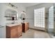 Bathroom with dual vanities, round mirrors, and a tiled shower at 13130 Meergate Cir, Orlando, FL 32837