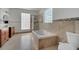 Bright bathroom features a soaking tub, glass block window, and tiled floor at 13130 Meergate Cir, Orlando, FL 32837