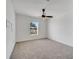 Spacious bedroom featuring plush carpet, a ceiling fan, and a bright window at 13130 Meergate Cir, Orlando, FL 32837