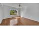 Light-filled bedroom with hardwood floors, ceiling fan, and a large window with a view of the outdoors at 13130 Meergate Cir, Orlando, FL 32837