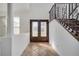 Bright and airy foyer featuring tile flooring and staircase with wood railing and iron spindles at 13130 Meergate Cir, Orlando, FL 32837